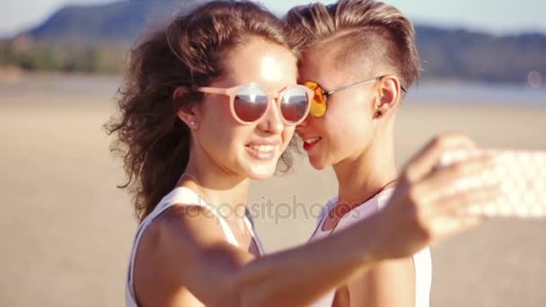 Joven feliz lesbianas pareja haciendo selfie en la playa — Vídeos de Stock