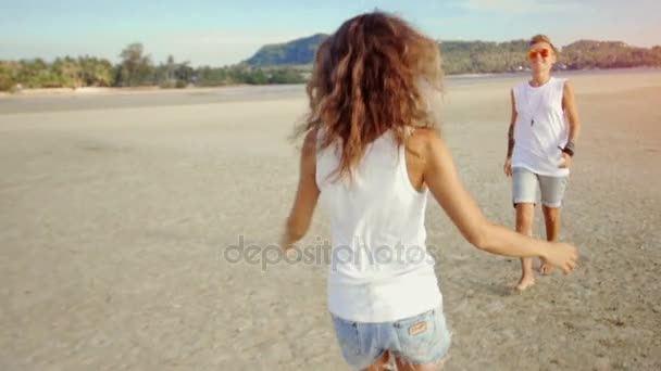 Pareja de lesbianas corren el uno al otro y abrazan en una playa — Vídeo de stock