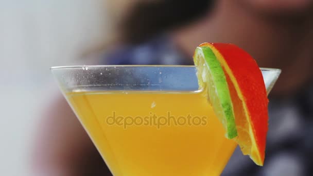 Close up de uma mulher desfrutando de um coquetel tropical decorado com frutas frescas — Vídeo de Stock