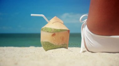 Kadın içki taze hindistan cevizi su ile saman plajda eğlenceli tatil