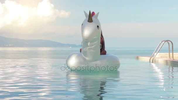 Attractive woman lying on Inflatable unicorn in swimming pool — Stock Video