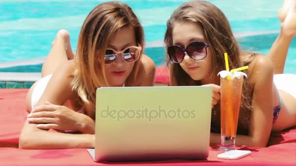 Duas jovens mulheres adultas trabalhando no laptop juntas — Vídeo de Stock