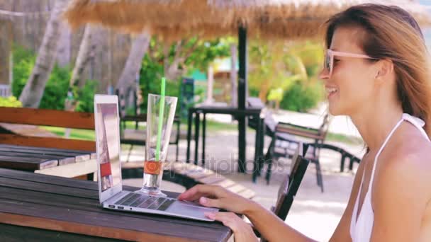 Mujer sentada en la playa y vídeo chat — Vídeo de stock