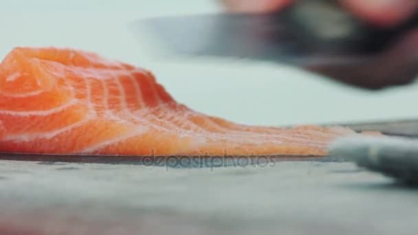 Sushi chef-kok plakjes verse zalm op de sushibar — Stockvideo