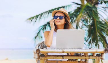 Sahilde içinde laptop çalışan genç kadın. Serbest çalışma