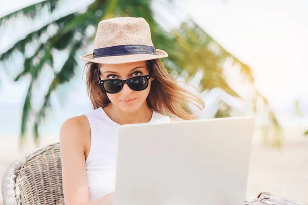 Junge Frau, die in Laptop am Strand arbeitet. Freiberufliche Tätigkeit — Stockfoto