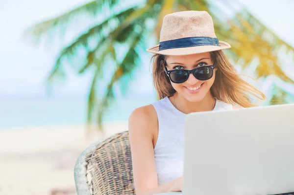 Junge Frau, die in Laptop am Strand arbeitet. Freiberufliche Tätigkeit — Stockfoto