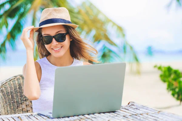 Молодая женщина работает в ноутбуке на пляже. Фрилансерская работа — стоковое фото