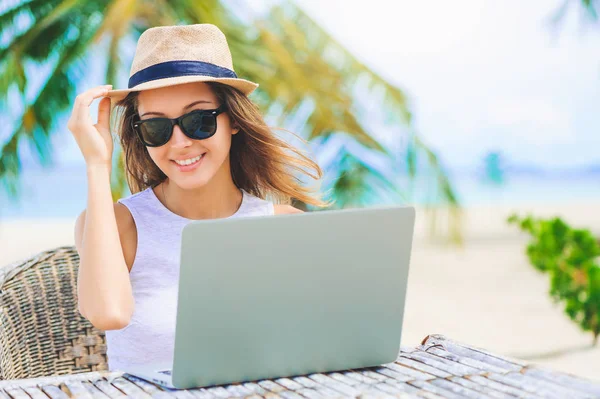 Sahilde içinde laptop çalışan genç kadın. Serbest çalışma