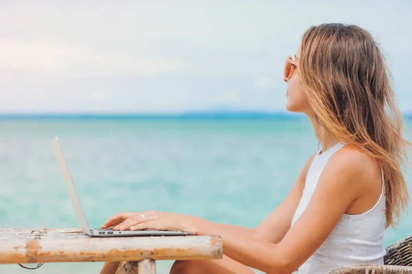 Jeune femme sexy utilisant un ordinateur portable sur la plage. Travail indépendant — Photo