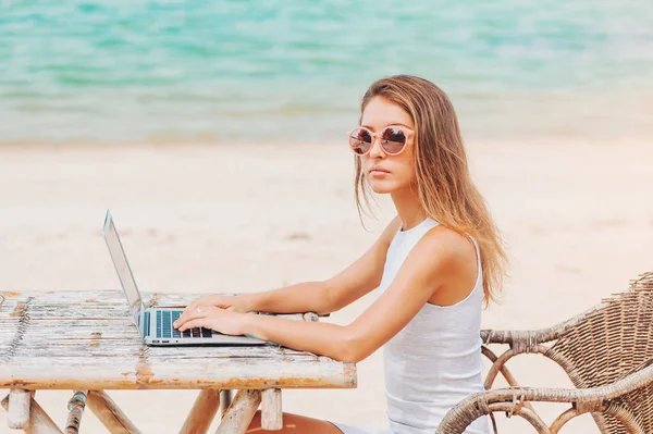 Jonge sexy vrouw met laptop op het strand. Freelance werk — Stockfoto