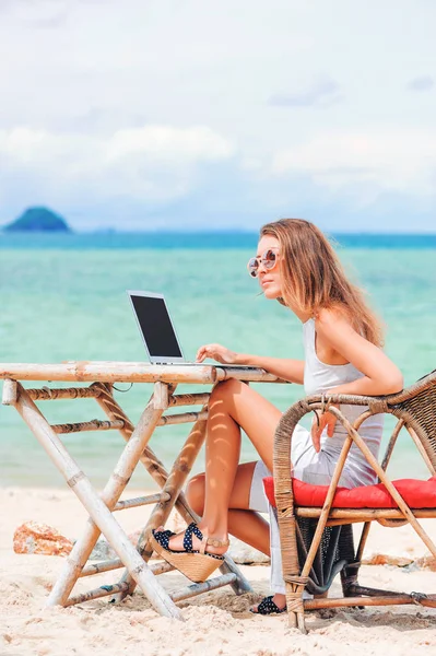 Jeune femme sexy utilisant un ordinateur portable sur la plage. Travail indépendant — Photo