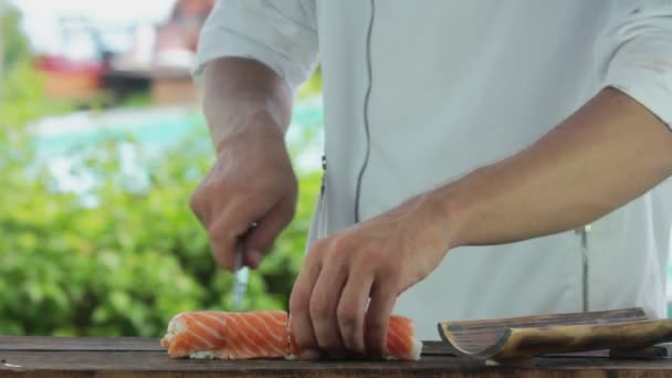 Sushi Chef vágás lazac tekercs. A sushi-man főzés sushi tekercs — Stock videók