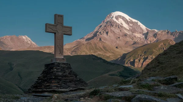 Cruz en Kazbegi con vista a la montaña Kazbek — Foto de Stock