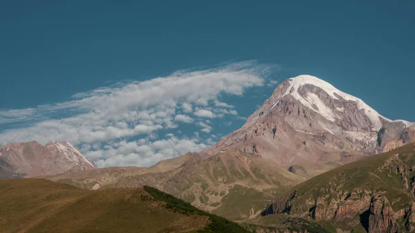 Mount Kazbek görünümü tırmanma için iyi bir hava Gürcistan'daki Stepantsminda kasabasından. Uyuyan bir değişken bir Stratovolkan ve Kafkasya büyük dağlar biridir. — Stok fotoğraf