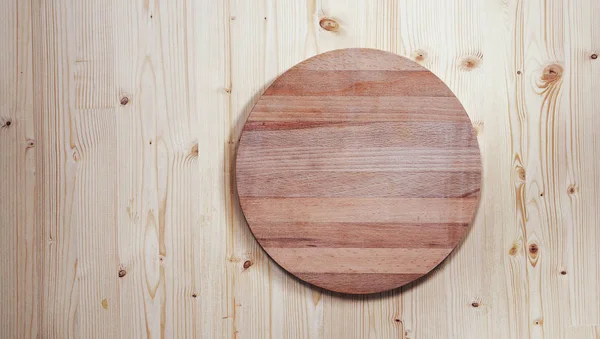 Tablero de madera redondo vacío para cortar sobre un fondo de madera — Foto de Stock