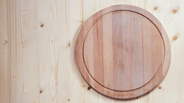 Empty round wooden board for cutting on a wooden background — Stock Image Empty round wooden board for cutting on a wooden background Stock Photo
