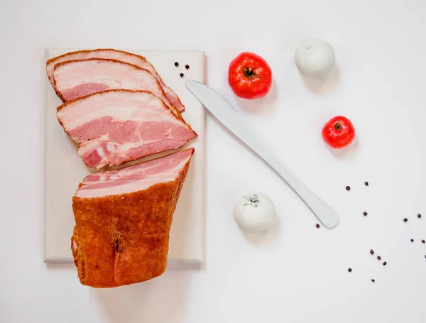 Bacon defumado na placa de corte branca — Fotografia de Stock