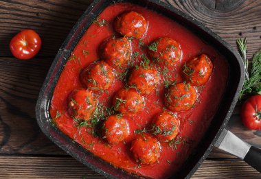 Tavada baharatlı domates soslu köfte. ahşap arka plan üzerinde