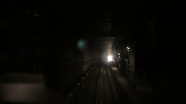 Câmera em movimento no túnel ferroviário escuro em direção a luz brilhante no final — Vídeo de Stock