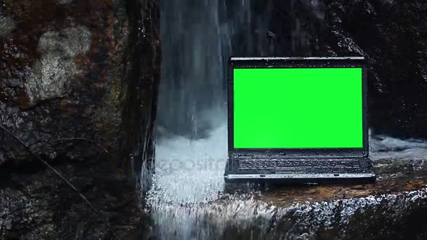 Laptop mit grünem Bildschirm unter Wasserfall — Stockvideo