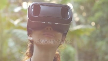 kadın bir sanal gerçeklik gözlük içinde orman 6 atış kullanır.