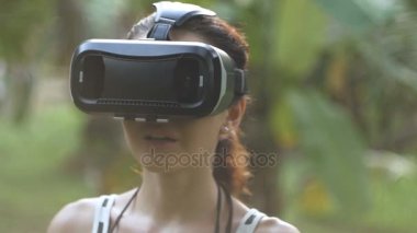 kadın ağır çekimde, yörünge atış ormanda bir sanal gerçeklik gözlük kullanır
