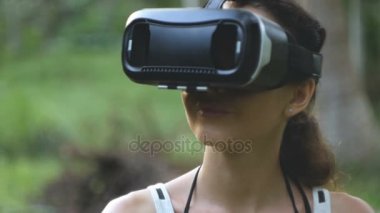 kadın ağır çekimde, yörünge atış ormanda bir sanal gerçeklik gözlük kullanır