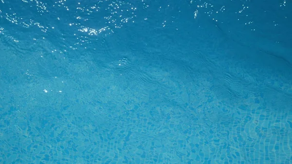 Água azul brilhante natural em uma piscina — Fotografia de Stock