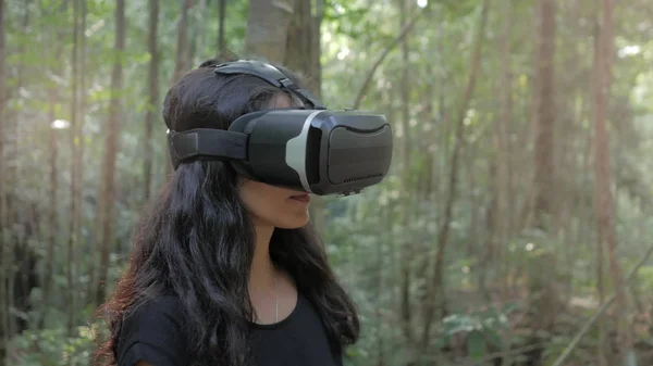 Beautiful young brunette woman use virtual reality glasses — Stock Photo, Image