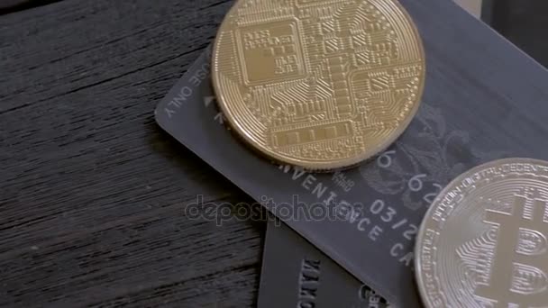 Bitcoins dorés et argentés avec des cartes de crédit sur fond en bois . — Video