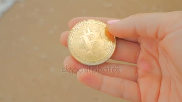Золотая монета BTC как символ электронных виртуальных денег в руке — стоковое видео