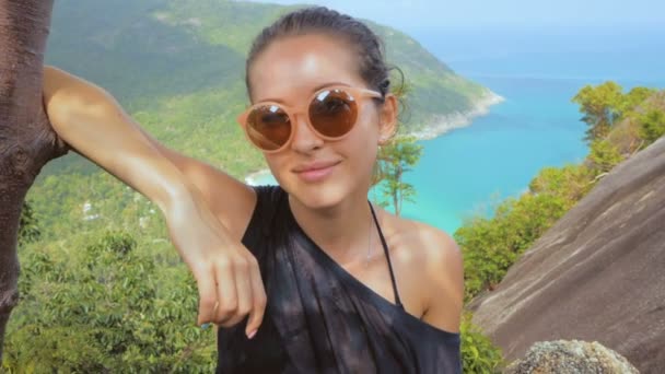 Chica disfrutar de pintoresca vista de la isla a una altura, sonriendo en la cámara — Vídeos de Stock