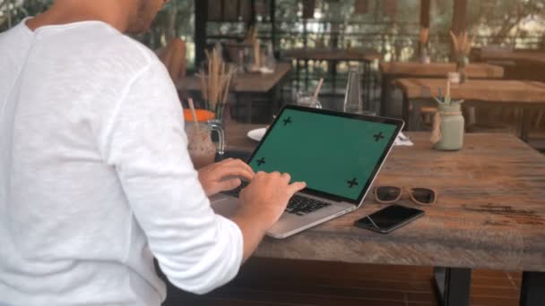 Primo piano di mani maschili che lavorano su un computer portatile con schermo verde in caffè — Video Stock