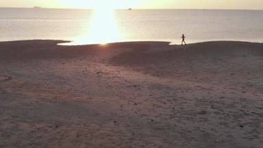 Sahilde sunset bulvarında koşu genç bir kadın. hava uçak atış, ağır çekim