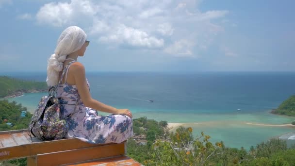 Unga turist kvinna sitter på viewpoint av vackra havet bay landskap — Stockvideo