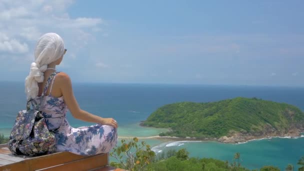 Jovem turista mulher está sentado no miradouro da bela paisagem da baía do mar — Vídeo de Stock