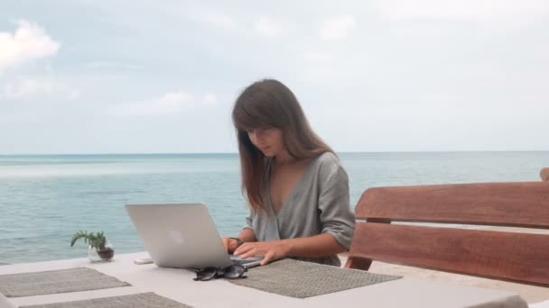 Jonge vrouw werkt op laptop op terras, draaiende camera stabilisator schot — Stockvideo