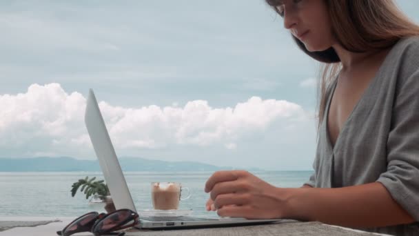 Jonge vrouw werkt op laptop op terras, bewegen van de camera, schot stabilisator — Stockvideo