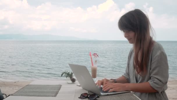 Młoda kobieta działa na laptopie w kawiarni na świeżym powietrzu, poruszanie kamery, stabilizator strzał — Wideo stockowe