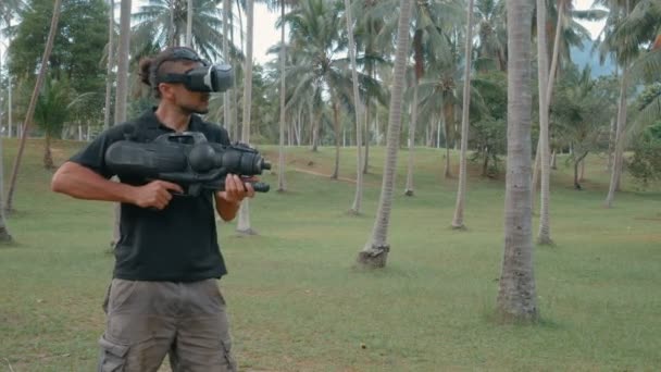 Man med vapen spela virtuell verklighet spel i djungeln — Stockvideo