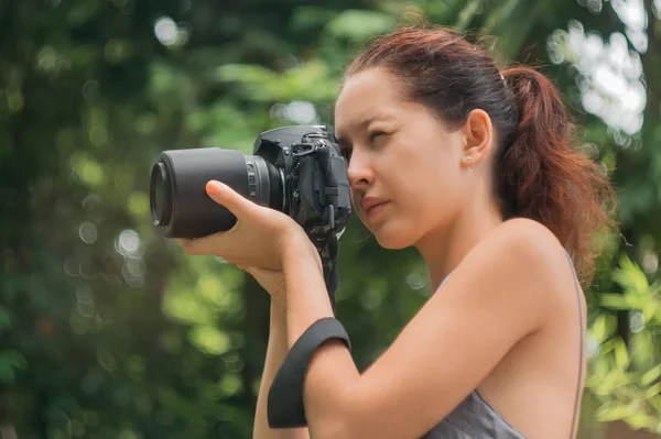 妇女是一个专业摄影师与单反相机, 软焦点, 自然散景 — 图库照片