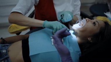 Hastanın yanında çalışan bir dişçi.