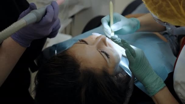 Un dentista en el trabajo con el paciente — Vídeos de Stock