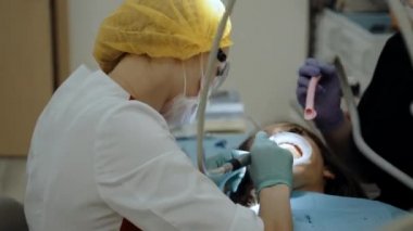Hastanın yanında çalışan bir dişçi.