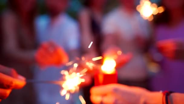 Друзья празднуют Рождество или Новый год бенгальскими огнями — стоковое видео