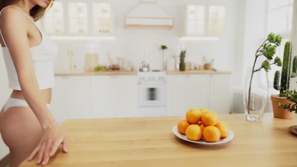 Beautiful sexy woman in white lingerie play with oranges — Stock Video