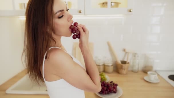 穿着白色内衣的漂亮性感女人吃葡萄 — 图库视频影像