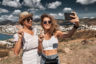 Mutlu arkadaş gezginler smatphone üzerinde selfie çekiyorlar.