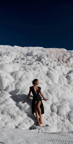 Young beautiful girl in black dress standing at natural pool Pamukkale — Stock Photo, Image